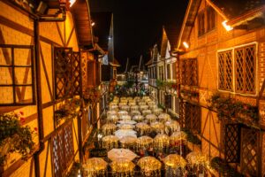 Gastronomia Charming European-style street in Campos do Jordão at night, adorned with festive lights and umbrellas.